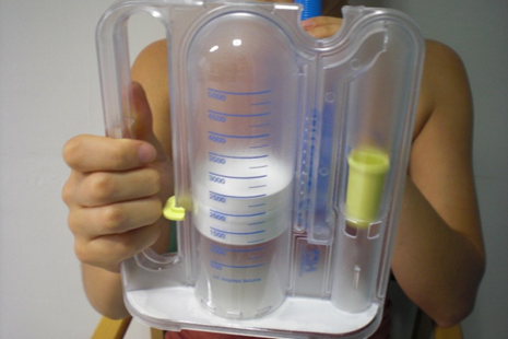 Close up of spirometer showing vertical tubes including one with gradations and a white plastic disc inside