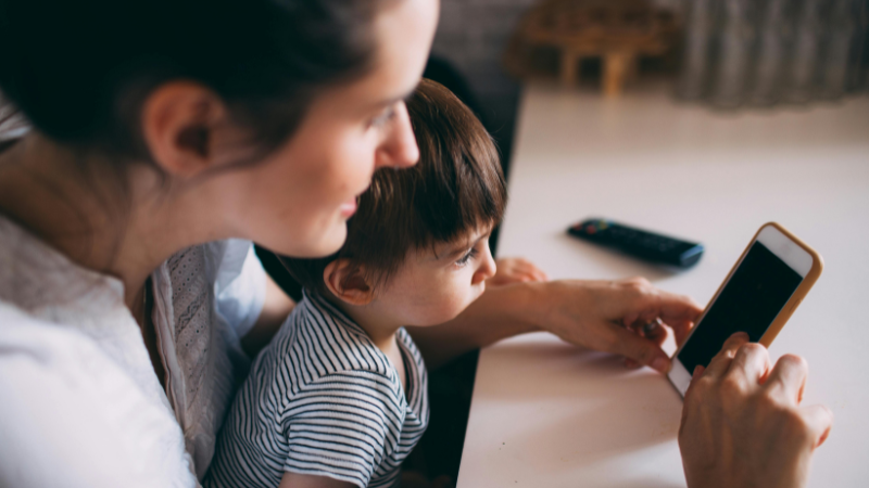 A mother and child looking at a mobile phone