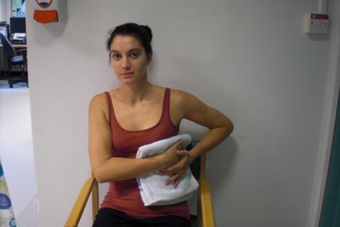 Person seated , holding a towel against their side